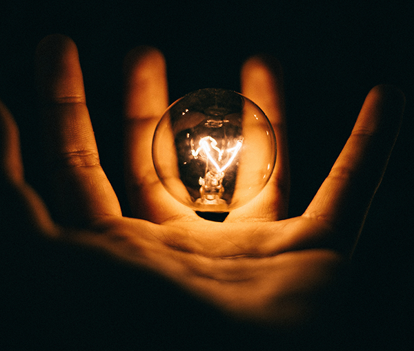 A light bulb in a man's hand - a metaphor for creativity