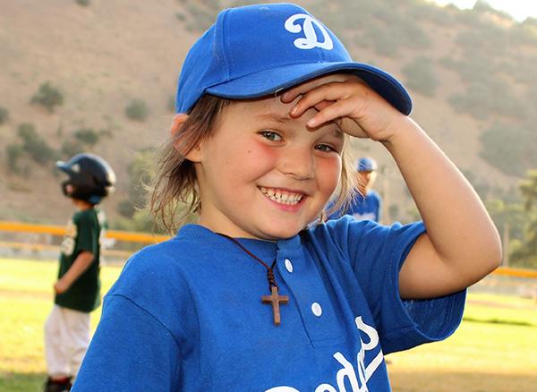 A young girl playing baseball