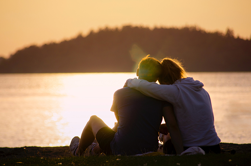 A young couple watching a sunset